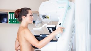 Mulher jovem fazendo exame de mamografia